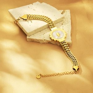 Detailed close-up of 18K gold plated stainless steel bracelet with sunburst shell charm