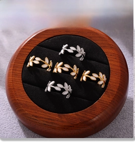 Macro view of leaf design rings with PVD gold plating in a wooden jewelry display box