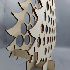 Close-up of wooden Christmas tree advent calendar wine holder with laser-cut edges