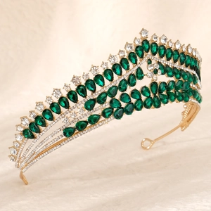 Macro shot of luxury gold tiara featuring emerald teardrop stones and sparkling crystals