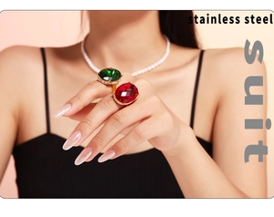 Detail eines vergoldeten Edelstahlrings mit großem ovalem Rubin und Perlenkette im Vintage-Stil