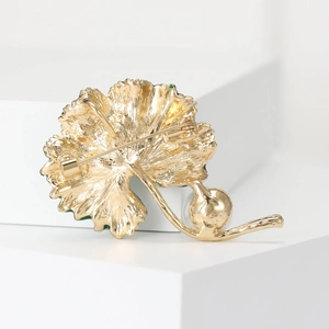 Elegant gold leaf-shaped brooch with enamel finish and pearl drop on geometric blocks