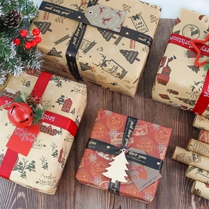 Kraft Christmas wrapping paper rolls with festive boxes on a wooden table with pine cones