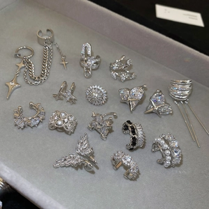 Macro view of assorted silver ear cuffs with zircon flowers and star-shaped details