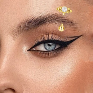 Close-up of G23 titanium curved eyebrow piercing with a sparkling gold zircon stud