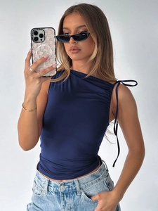 Detail of navy blue one-shoulder cropped top with side drawstrings and ruched texture
