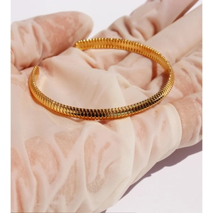 Golden spiral tubogas open cuff bracelet with sleek metallic texture and modern design