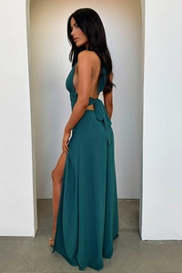 Detail of a dark green halter maxi dress featuring backless design and high leg slit