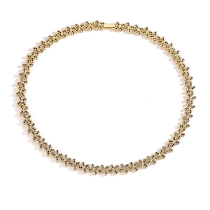 Flat lay of a gold necklace featuring black clover links with tiny sparkling rhinestones