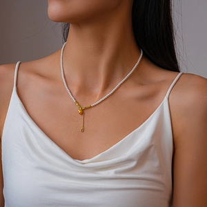 Détail du collier de perles avec pendentif gourde en or et pompon en zircon sur mannequin