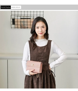 Model wearing a pink faux leather crossbody bag with a gold clasp and chain strap