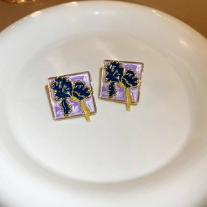 Detail of square vintage enamel earrings featuring blue iris patterns on purple finish