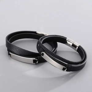Detail of multi-layer black leather woven bracelet with silver stainless steel ID plate