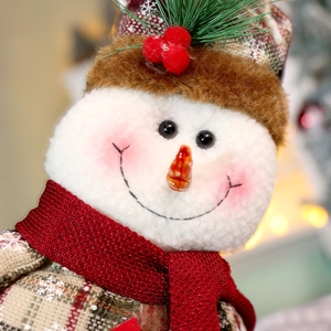 Dettaglio macro del pupazzo di neve in peluche con sciarpa a maglia e naso a carota