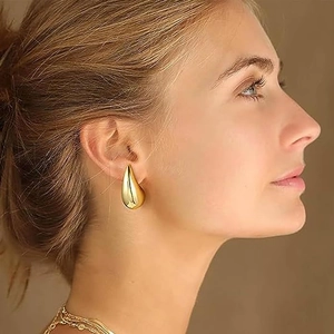 Polished 18k gold plated hollow teardrop earring shown on a female model