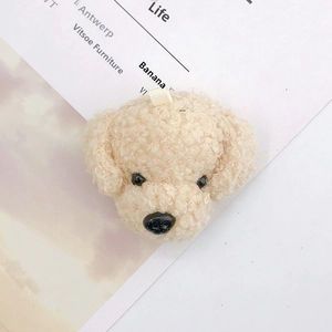 Close-up of beige plush teddy dog charm with curly fur texture and hanging loop detail