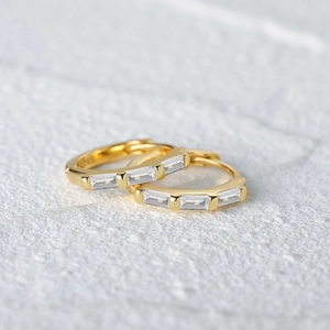 Macro shot of S925 sterling silver gold earrings with rectangular cut zircon stones