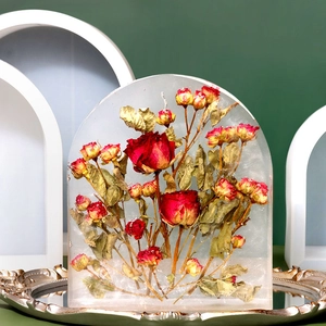 Arch resin paperweight with red roses displayed on a vintage silver mirror tray