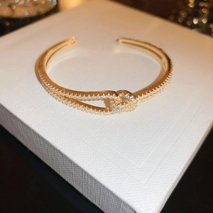Detail van 18k vergulde hoefijzer armband met zirkonia pavé op een luxe geschenkverpakking