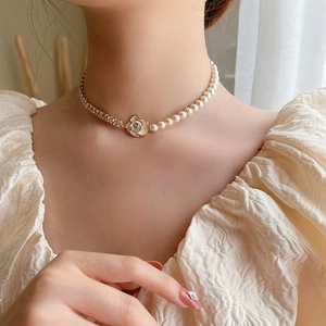 Elegant detail view of a French style necklace with camellia pendant, zircon and pearls.