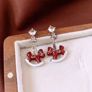 Detail of red enamel rocking horse earrings with sparkling cubic zirconia on silver pins