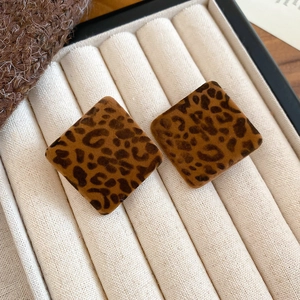 Close-up of leopard print square stud earrings with soft velvet texture in jewelry box