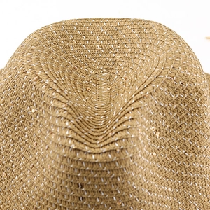 Close-up of woven straw hat texture with shimmering sequins and natural khaki fibers