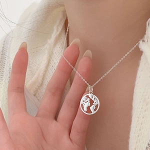 925 silver necklace with world map pendant shown on model with white sweater