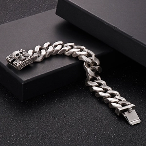 Detail of vintage silver skull clasp and heavy curb chain on men's steel bracelet
