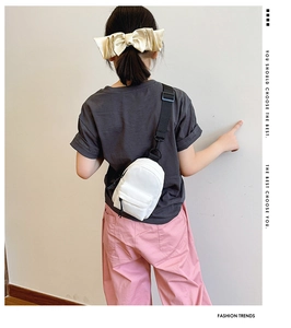 Rear view of white mini crossbody chest bag for kids with adjustable black shoulder strap