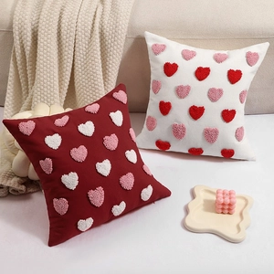 Red and white Valentine's Day tufted heart throw pillows on a cozy sofa