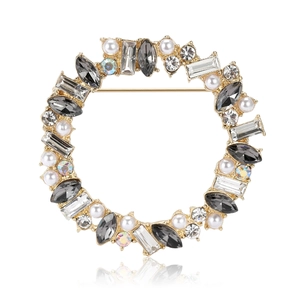 Elegant gold wreath brooch with grey rhinestones and pearls on white background