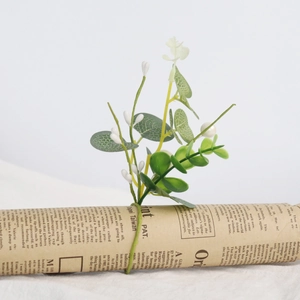 Detail showing artificial eucalyptus leaves and white buds on a vintage pine needle napkin ring