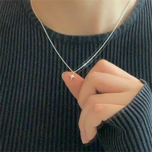Minimalist 925 sterling silver necklace with four-pointed star pendant on woman neck