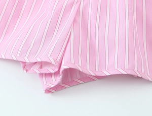 Detail of pink and white striped cotton fabric with precise hem stitching for summer set