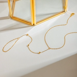 Détail de la chaîne en acier doré 18K avec perles délicates et fermoir mousqueton robuste