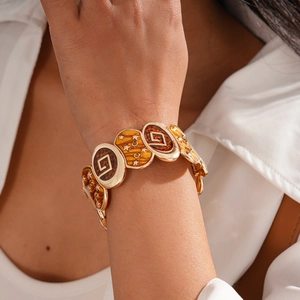 Detail of vintage gold bracelet with brown enamel stars and bohemian oval links