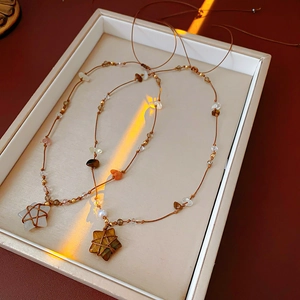 Détail de colliers avec pendentifs étoiles en pierre œil de tigre et corde tressée main