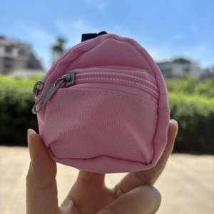 Close-up of a pink mini backpack coin purse with dual zippers and durable canvas texture