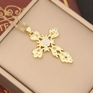 Detail of 18K gold cross pendant with micro-inlaid zircons in a jewelry box