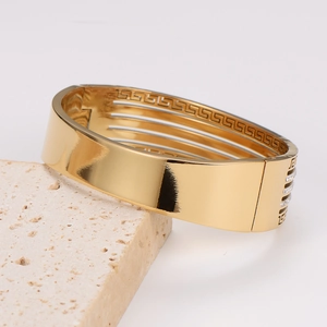 Breiter goldener Edelstahl-Armreif mit Mäander-Muster und weißen Zirkonia-Steinen