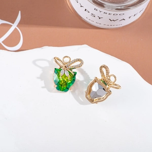 Detailed view of apple-shaped crystal pendants with rhinestones on a textured stone