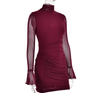 Détail de la robe en mesh bordeaux avec col montant, manches évasées et plis élégants