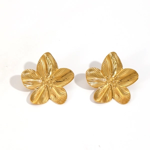 Close-up of golden 3D flower earrings with brushed metal texture and center bead details