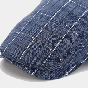 Gros plan sur la texture du tissu à carreaux bleus d'une casquette plate vintage