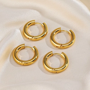 Chunky 18K gold plated stainless steel hoop earrings on elegant champagne silk fabric