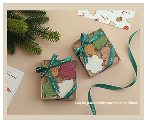 Christmas gift set with scented candles in snowman and tree shapes in a ribbon box
