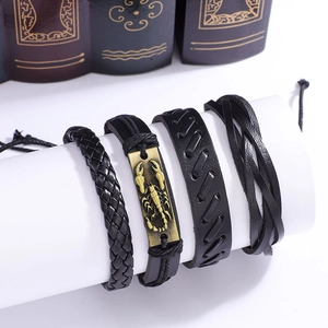 Détail d'un lot de quatre bracelets en cuir noir avec un pendentif scorpion doré chic