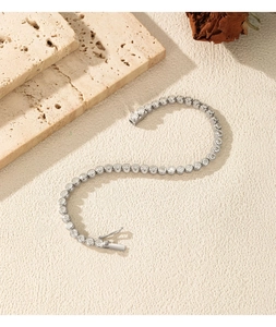 Detail van S925 zilveren tennisarmband met moissanite op een ondergrond van travertijn