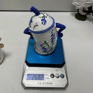 Blue floral ceramic storage jar with lid and side handles on a weighing scale